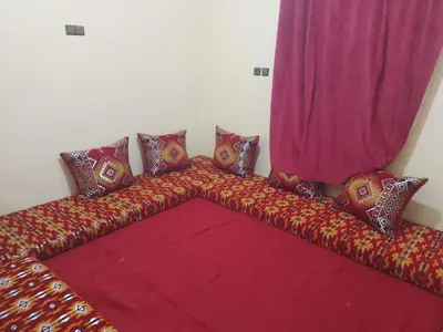 a couch with colorful pillows and a curtain at Chez zakaria guest house in Merzouga
