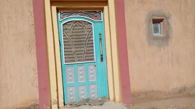 a blue door with a window on a building at Chez zakaria guest house in Merzouga