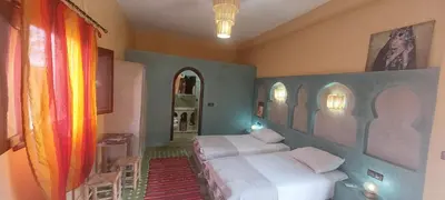 a bedroom with two beds in a room at Maison Vallée Du Ziz in Ouled Aissa