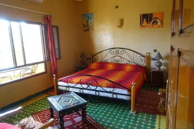 a bedroom with a bed and a window at Maison Vallée Du Ziz in Ouled Aissa