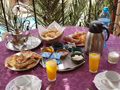 a purple table with breakfast foods and drinks on it at Maison Vallée Du Ziz in Ouled Aissa
