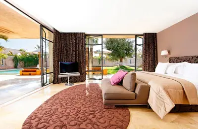 a bedroom with a bed and a couch and a tv at Palais Namaskar in Marrakech
