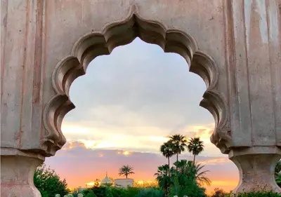 an arch in a building with a sunset in the background at Palais Namaskar in Marrakech