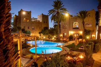 a large house with a swimming pool at night at Ksar Elkabbaba Kasbah & SPA in Skoura