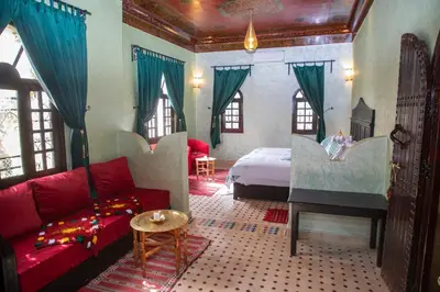 a living room with a bed and a couch and a room with a bed sqor at Ksar Elkabbaba Kasbah & SPA in Skoura