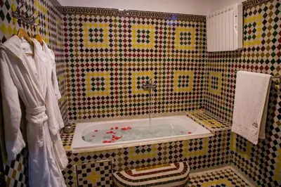 a bathroom with a tub in a tiled wall at Ksar Elkabbaba Kasbah & SPA in Skoura
