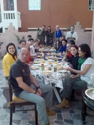 a group of people sitting around a long table at riad lala fatima in Ouzoud