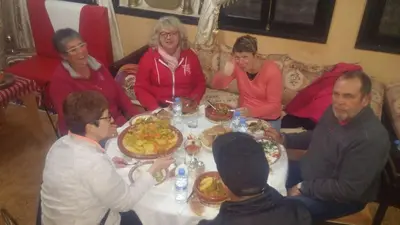 a group of people sitting around a table eating food at riad lala fatima in Ouzoud