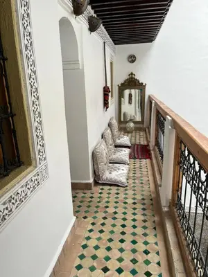 a hallway with two chairs and a rug on the floor at Riad Fes EL KAID in Fès
