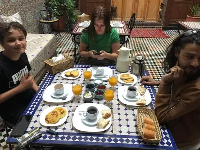 a group of people sitting at a table eating breakfast at Riad Fes EL KAID in Fès