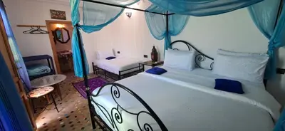 a bedroom with a large bed with a canopy at Riad Fes EL KAID in Fès