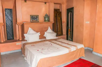 a bedroom with a large bed with white pillows at Riad Kasbah Omar in Ourika