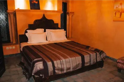 a bedroom with a large bed with a wooden headboard at Riad Kasbah Omar in Ourika