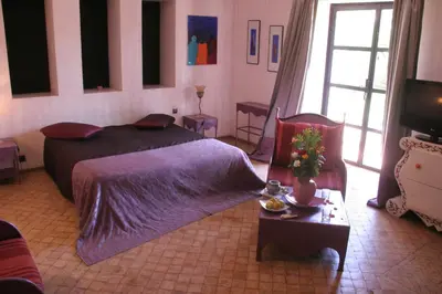 a bedroom with a bed with a purple comforter at VILLA CATHERINE MARRAKECH in Marrakech