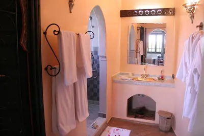 a bathroom with a fireplace and a sink and a mirror at VILLA CATHERINE MARRAKECH in Marrakech