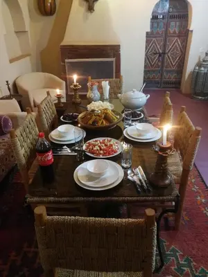 a table with plates of food and candles on it at Chez Kossai Atlas Farm in Chtawna