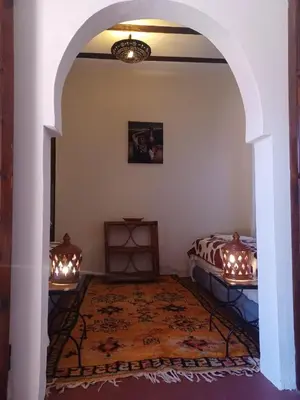 a bedroom with a bed and an archway with lights at Chez Kossai Atlas Farm in Chtawna