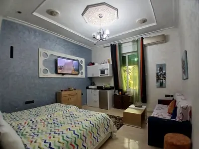 a bedroom with a bed and a tv on the wall at Ryan S1et Ryan S2 in Fès