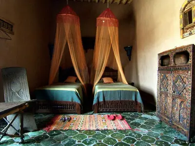 a bedroom with two beds with red shoes on the floor at Le Sauvage Noble in Tissergat