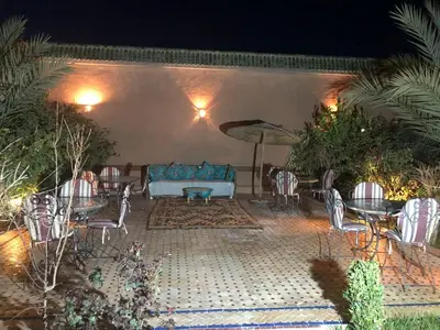 a patio with a couch and chairs and an umbrella at Le Sauvage Noble in Tissergat