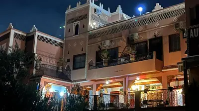 a large building with a balcony at night at Kasbah La Famille Berbère in Boumalne