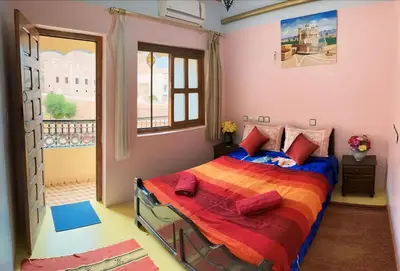 a bedroom with a bed and a window at Kasbah La Famille Berbère in Boumalne