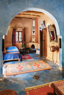 a bedroom with two beds in a room with an archway at Le Chant Des Palmiers in Agdz