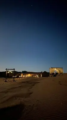 a desert at night with a tent in the desert at Original Desert Camp in Merzouga