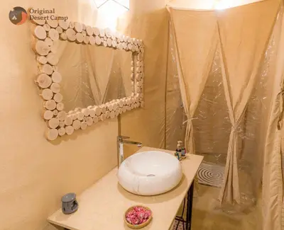 a bathroom with a toilet sitting on a table at Original Desert Camp in Merzouga
