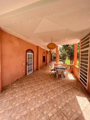 an empty patio with a table and chairs and a ceiling at Villa privée Wafa in Marrakech