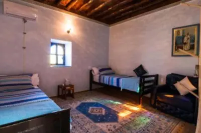 a bedroom with two beds and a couch in a room at Villa privée Wafa in Marrakech