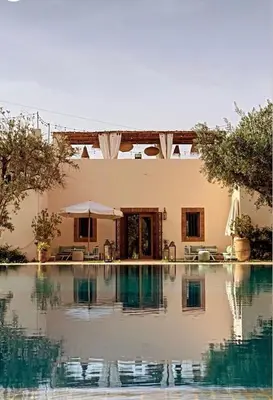 a swimming pool in front of a house at Upupa de l’Atlas in Marrakech