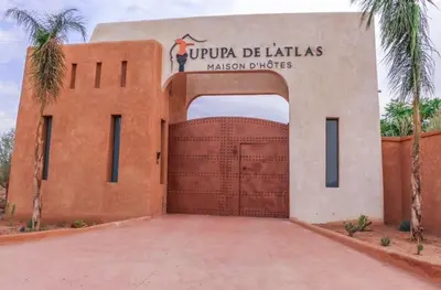 a brick building with a gate with a sign on it at Upupa de l’Atlas in Marrakech