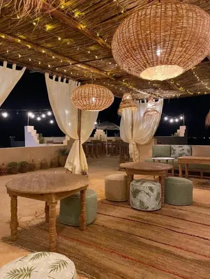 a room with two tables and benches and lights at Upupa de l’Atlas in Marrakech