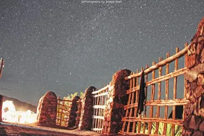 a starry night with a fence in front of a building at ecolodge bivouac des aigles in Ouarzazate