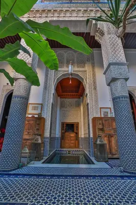 a lobby with blue and white columns and a swimming pool at RIAD LOUDAYA AND SPA in Fès