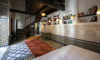 a room with a bed and a tiled wall at RIAD LOUDAYA AND SPA in Fès