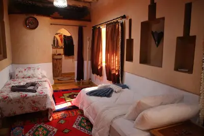 a living room with two beds and a window at Dar Mezyana Dades in Aït Idaïr