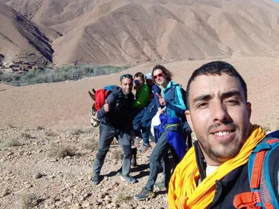 a group of people hiking in the desert at Dar Mezyana Dades in Aït Idaïr