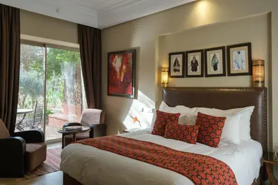 a hotel room with a bed and a large window at Le Clos des Oliviers in Oulad Jellal