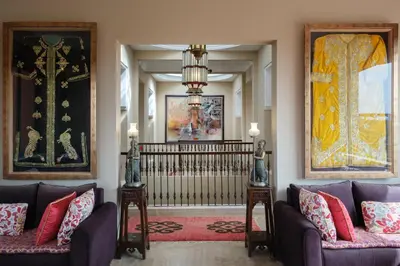 a living room with two couches and a chandelier at Le Clos des Oliviers in Oulad Jellal