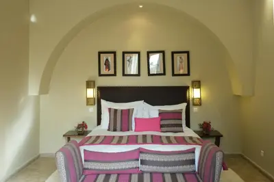 a bedroom with a large bed with pink pillows at Le Clos des Oliviers in Oulad Jellal