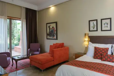 a hotel room with a bed and a chair at Le Clos des Oliviers in Oulad Jellal