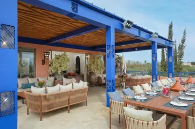 a pergola with tables and chairs on a patio at Le Clos des Oliviers in Oulad Jellal