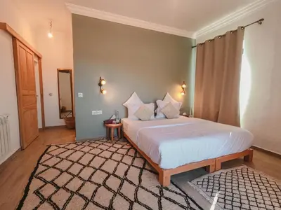 a bedroom with a large white bed in a room at AdaZen Ecolodge - Ait Bouguemez in Azilal