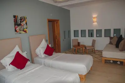 a hotel room with two beds with red pillows at AdaZen Ecolodge - Ait Bouguemez in Azilal