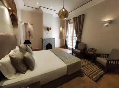 a bedroom with a bed and a living room with a fireplace at Privat Villa in Marrakesch with Pool & Garten in Marrakech