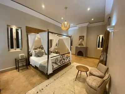 a bedroom with a canopy bed and a chair at Privat Villa in Marrakesch with Pool & Garten in Marrakech