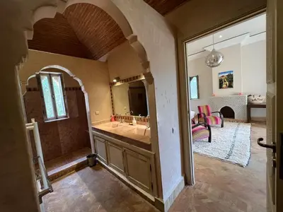 a bathroom with a sink and a large mirror at Privat Villa in Marrakesch with Pool & Garten in Marrakech