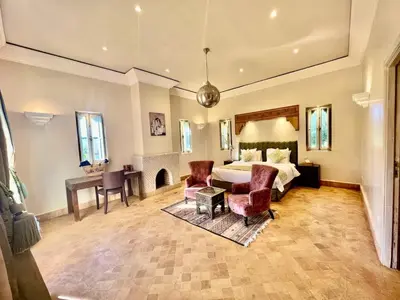 a large bedroom with a bed and a desk and chairs at Privat Villa in Marrakesch with Pool & Garten in Marrakech